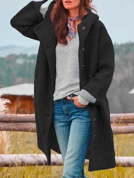 Woman wearing long hooded button coat with side pockets