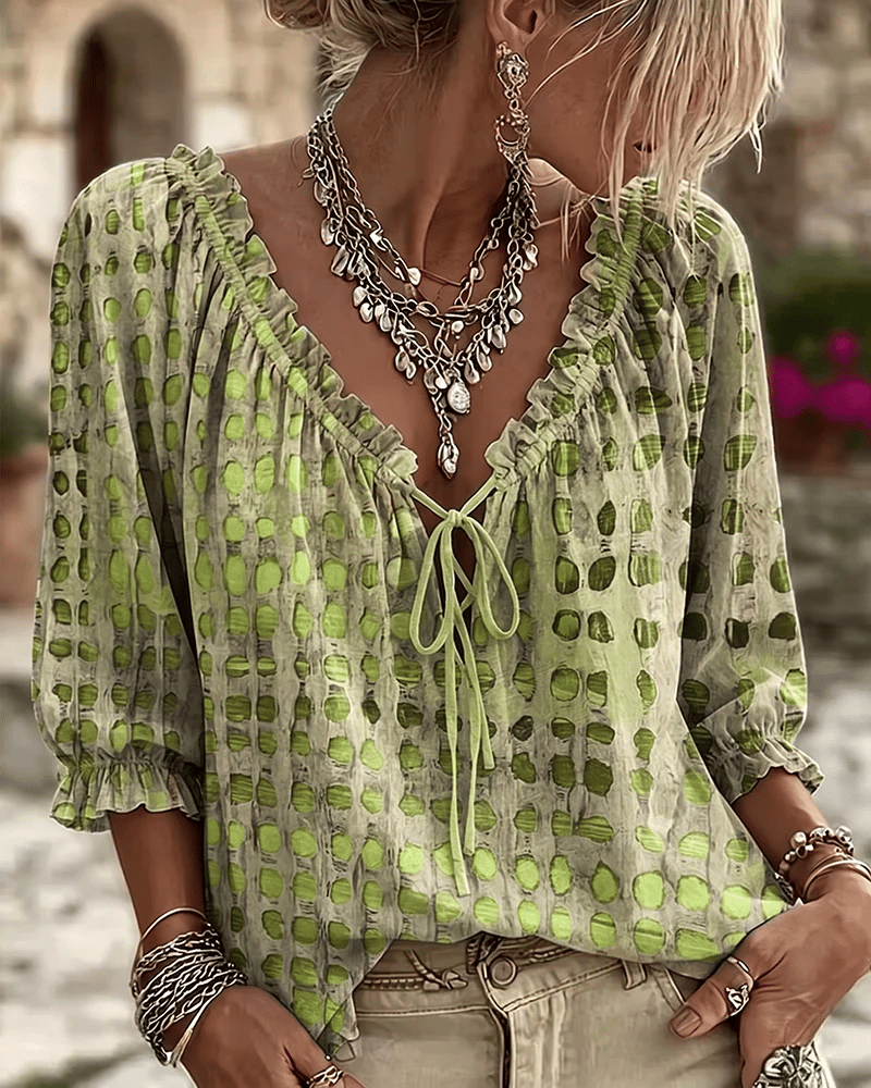 Woman wearing polka dot blouse with V-neck and puff sleeves