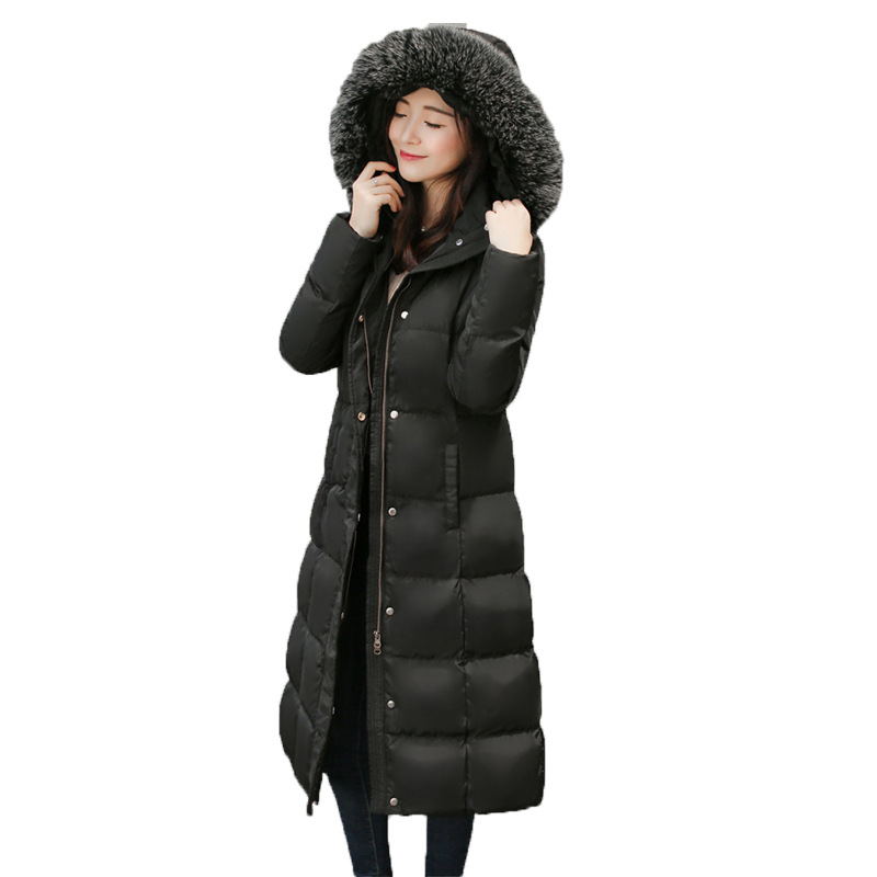 Woman wearing long hooded down jacket with fur collar