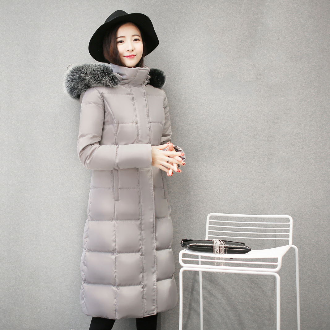 Woman wearing long hooded down jacket with fur collar
