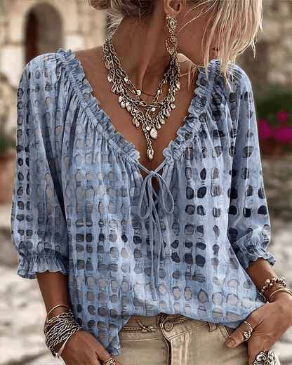 Woman wearing polka dot blouse with V-neck and puff sleeves