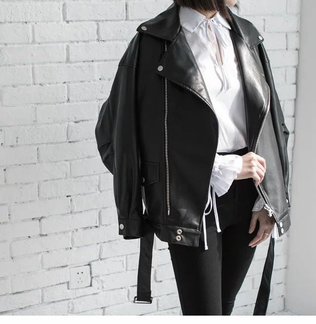 Woman wearing black faux leather motorcycle jacket with belt