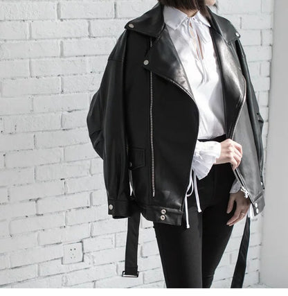 Woman wearing black faux leather motorcycle jacket with belt