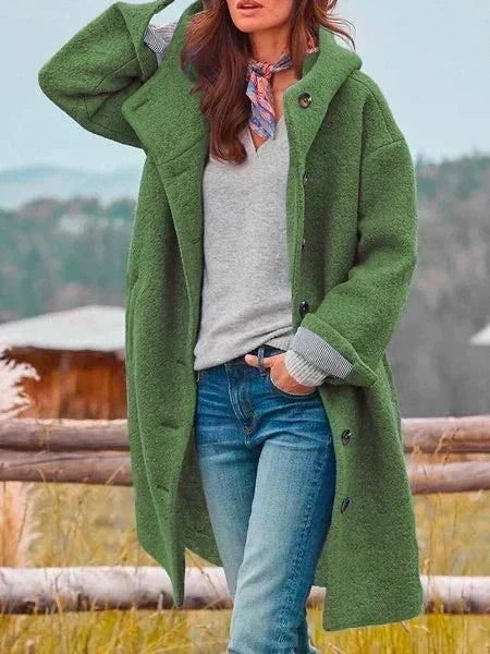 Woman wearing long hooded button coat with side pockets