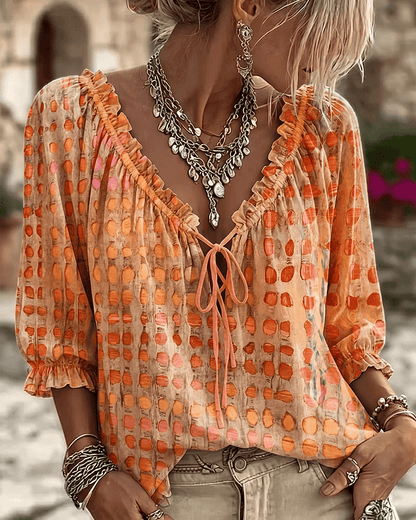Woman wearing polka dot blouse with V-neck and puff sleeves