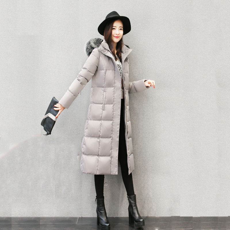 Woman wearing long hooded down jacket with fur collar