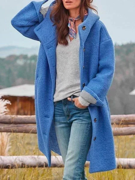 Woman wearing long hooded button coat with side pockets