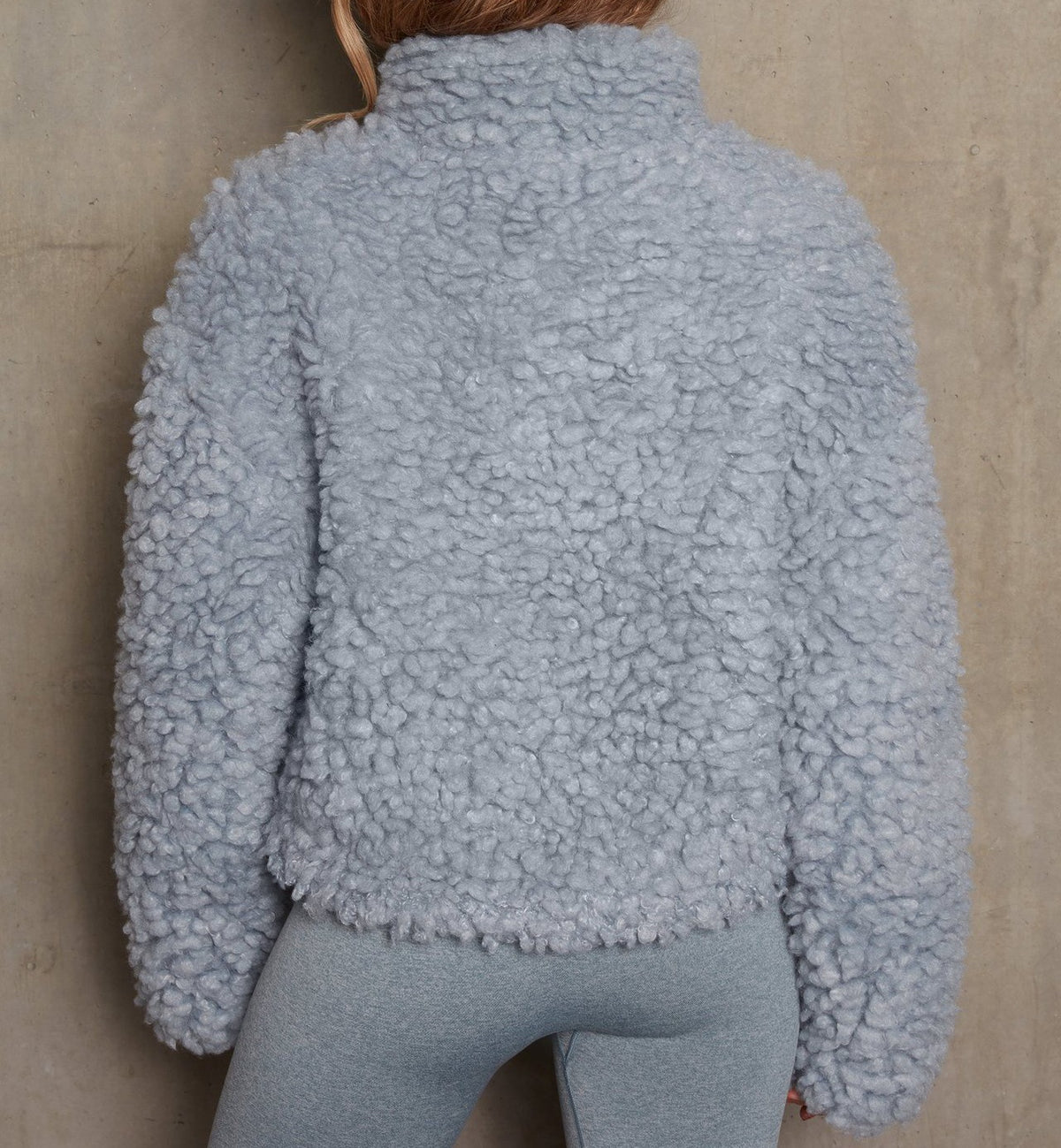 Woman wearing short open-front cardigan jacket indoors