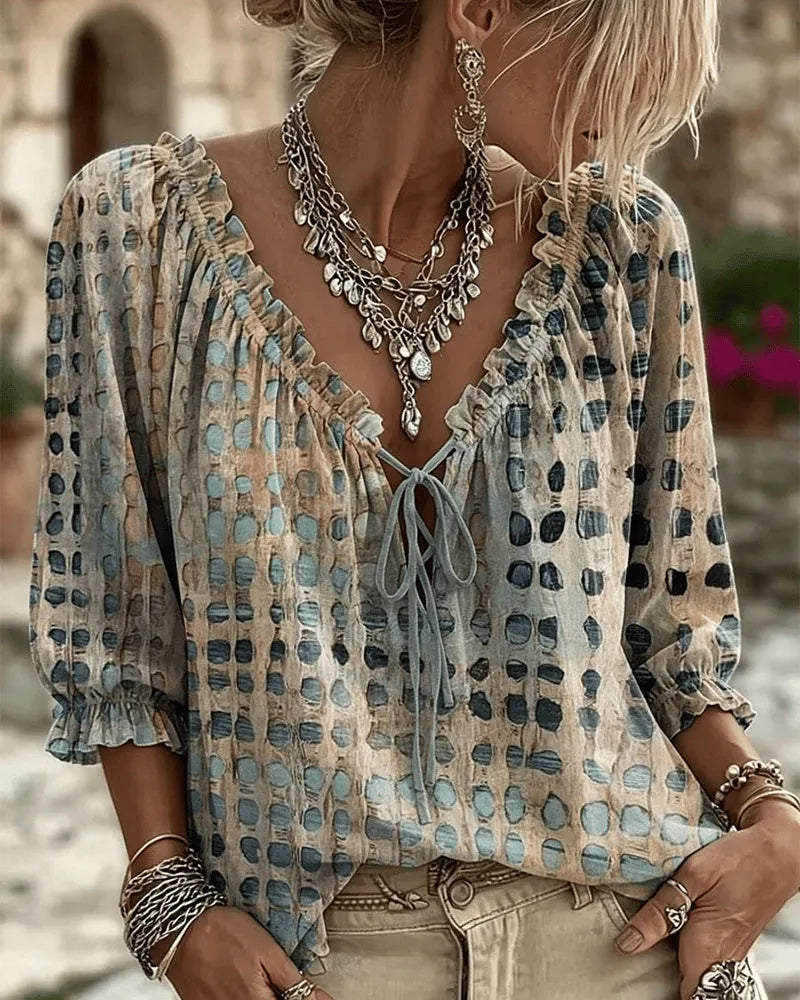 Woman wearing polka dot blouse with V-neck and puff sleeves