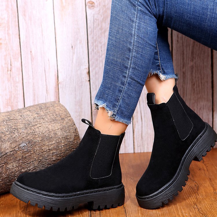 Woman wearing black short Martin boots with jeans