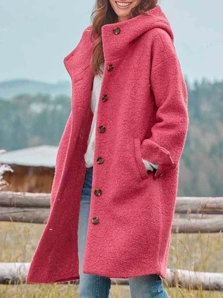 Woman wearing long hooded button coat with side pockets
