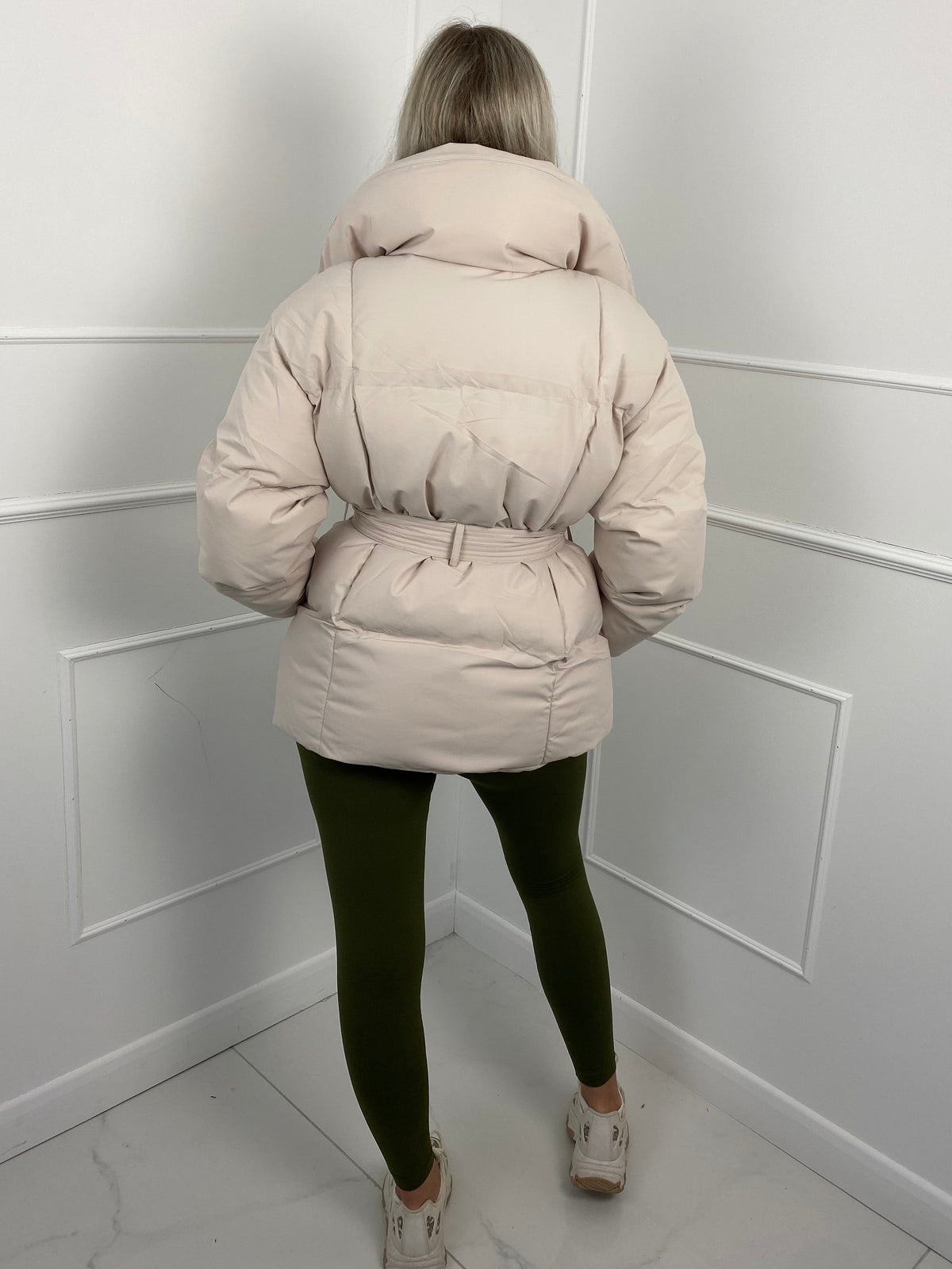 Woman wearing quilted puffer jacket with belt
