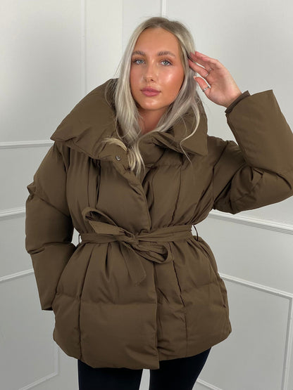 Woman wearing quilted puffer jacket with belt