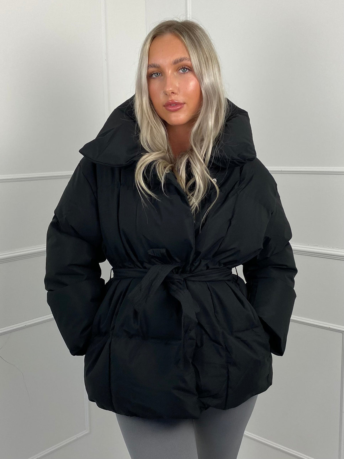 Woman wearing quilted puffer jacket with belt