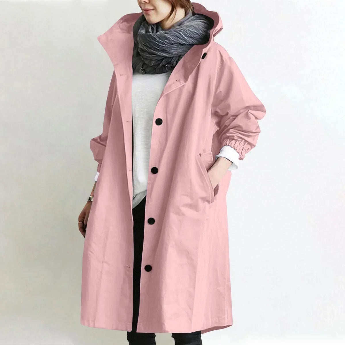 Woman wearing long hooded coat with front buttons