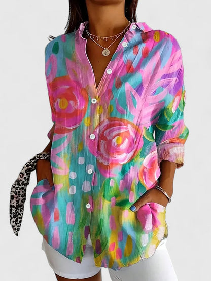 Woman wearing printed button-up blouse in bold colors