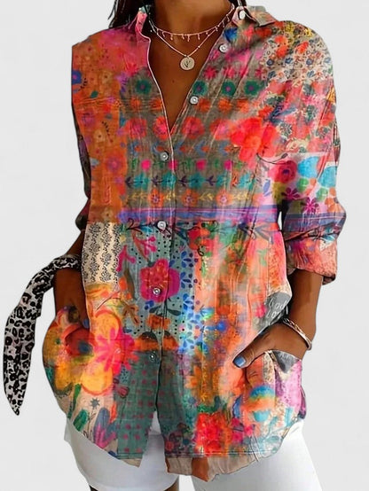 Woman wearing printed button-up blouse in bold colors