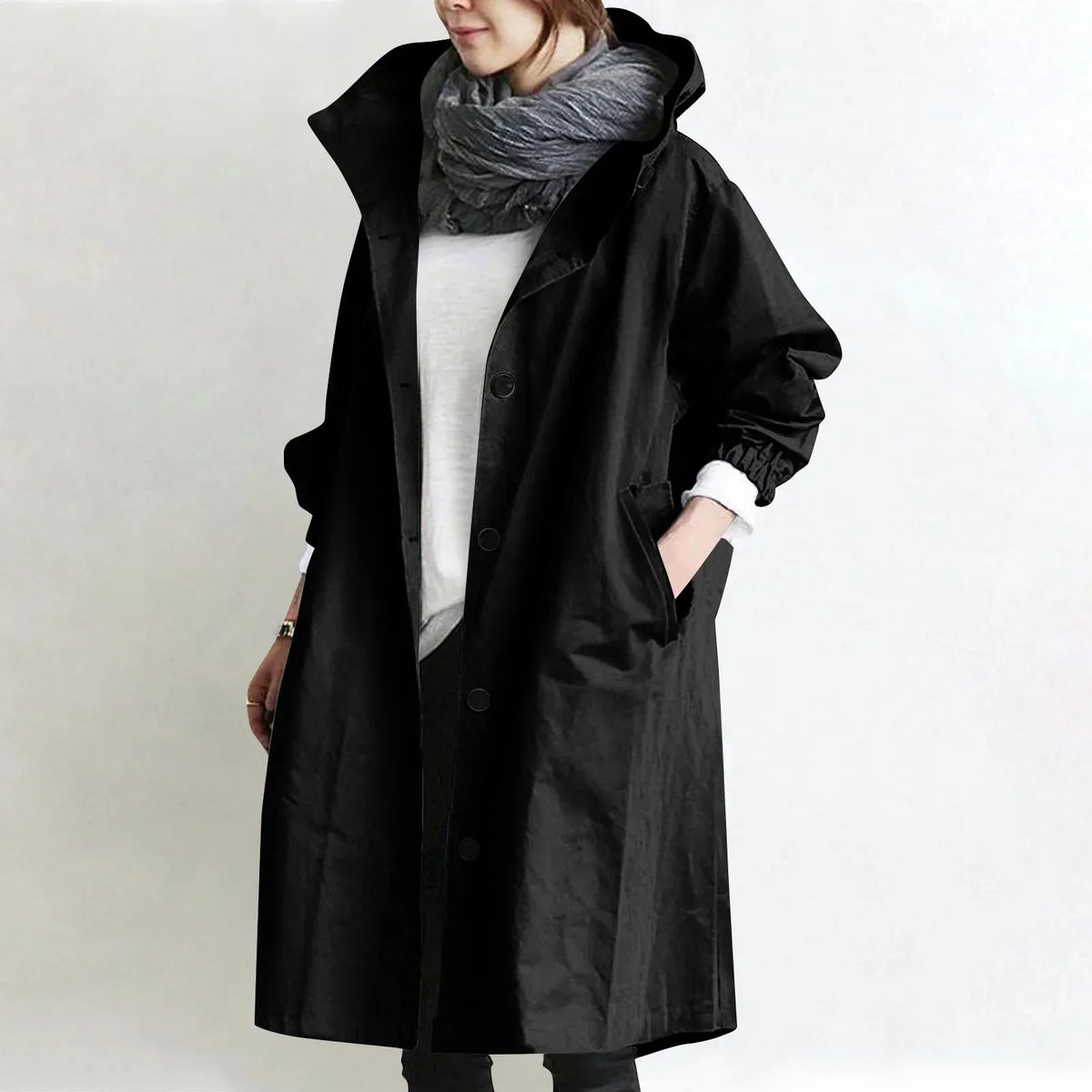 Woman wearing long hooded coat with front buttons