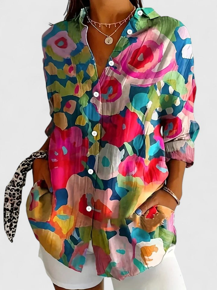 Woman wearing printed button-up blouse in bold colors