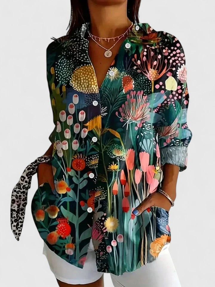 Woman wearing printed button-up blouse in bold colors