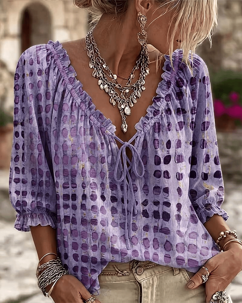 Woman wearing polka dot blouse with V-neck and puff sleeves