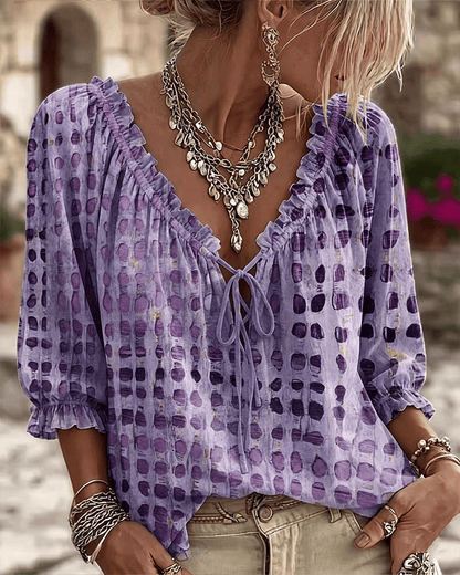 Woman wearing polka dot blouse with V-neck and puff sleeves