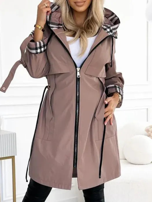 Woman wearing long coat with plaid hood