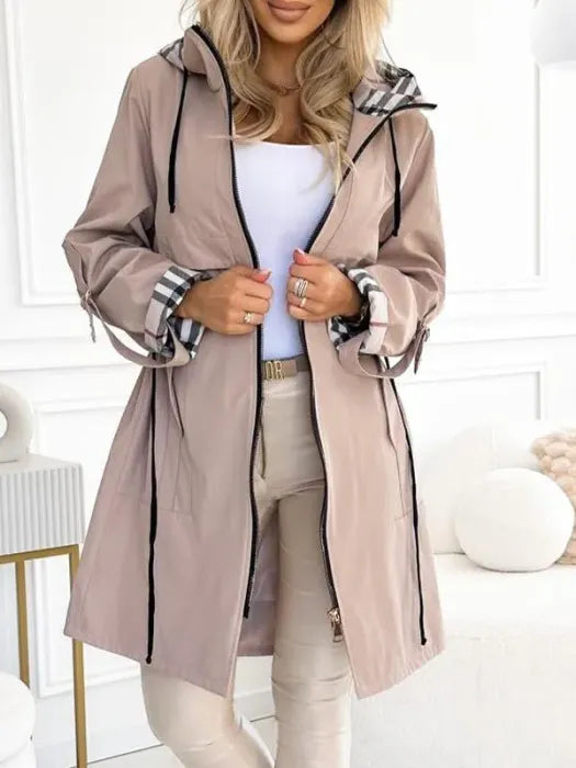 Woman wearing long coat with plaid hood