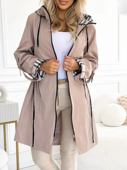 Woman wearing long coat with plaid hood
